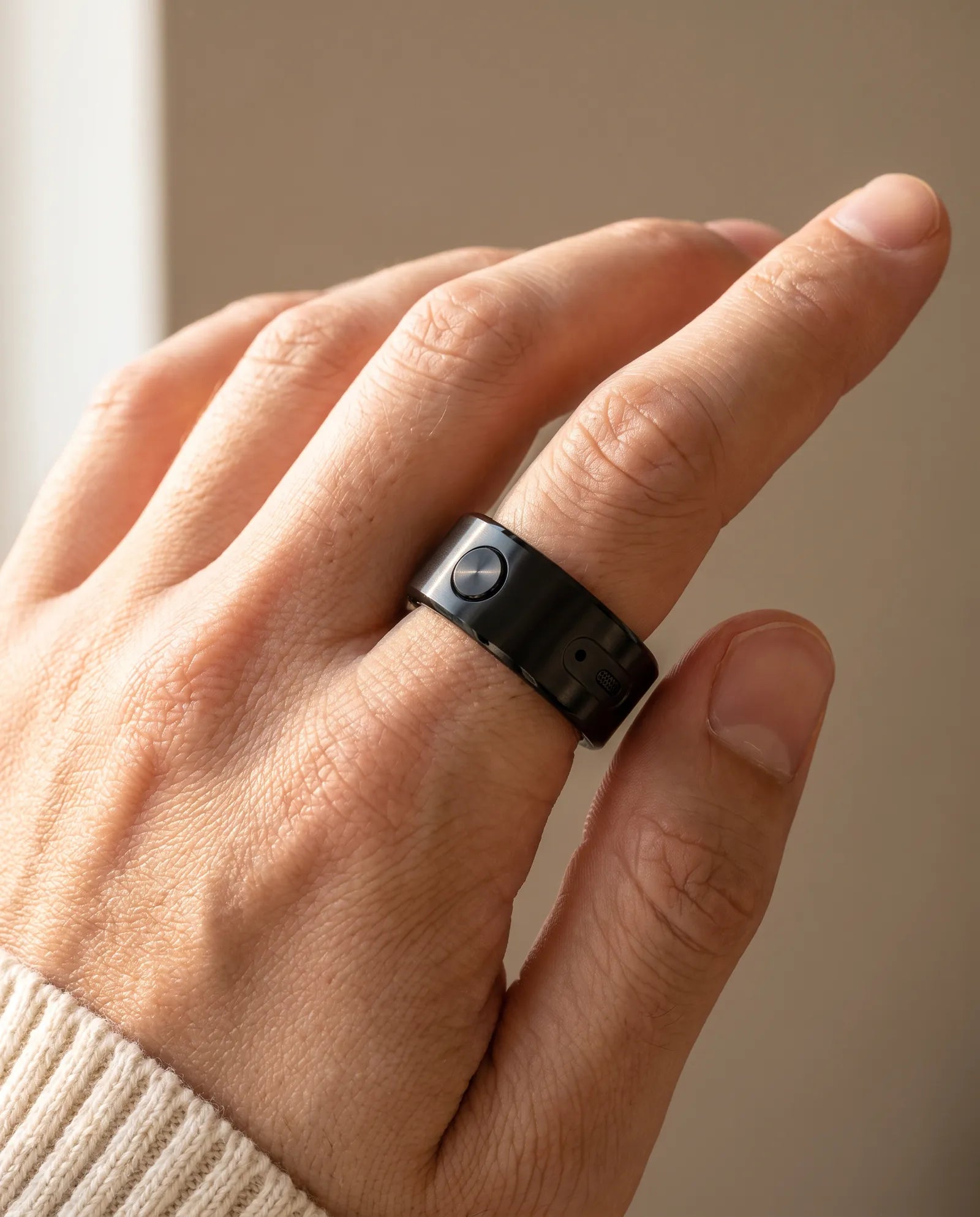 A hand wearing the black ring