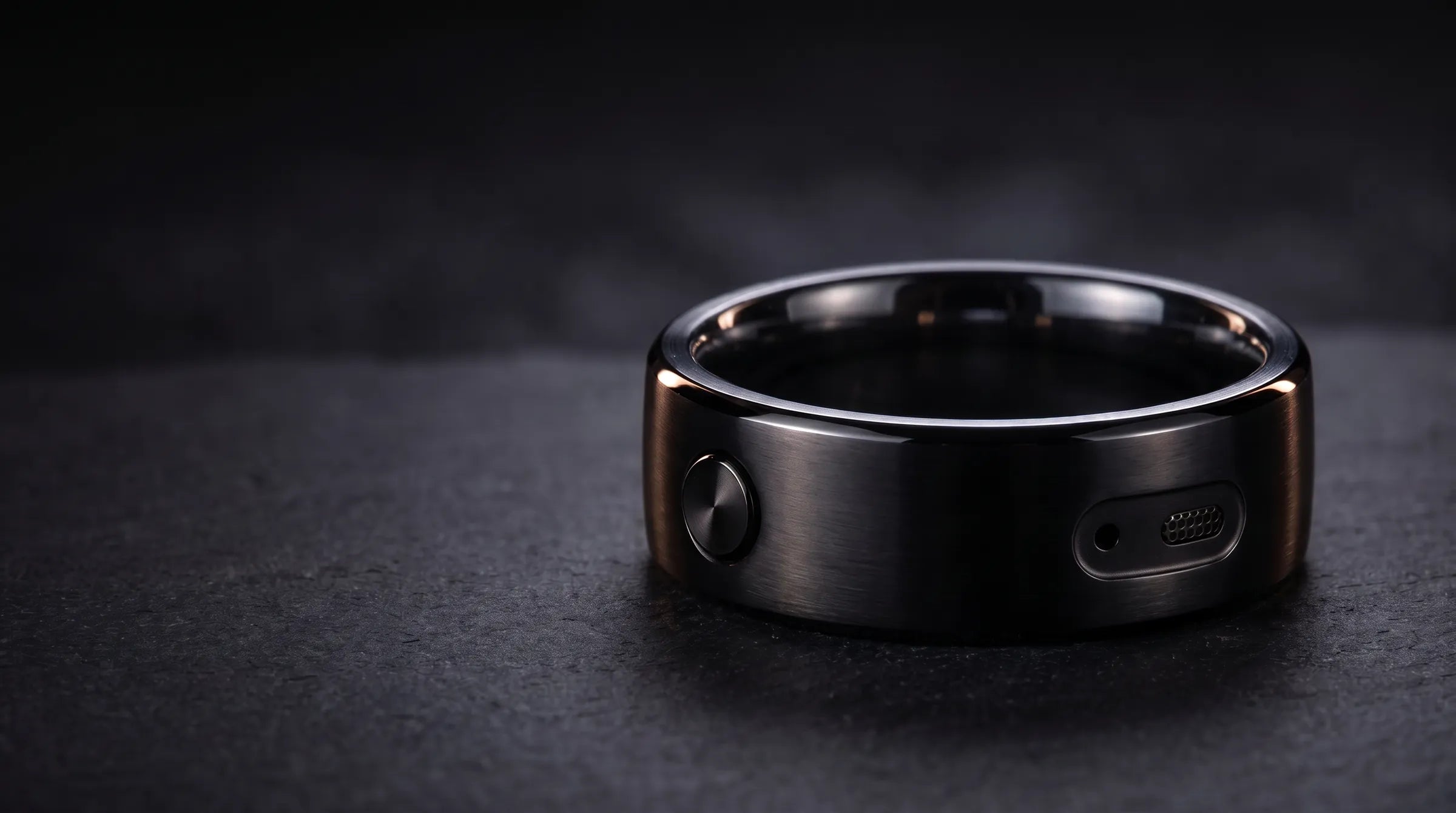 Revaudo AI Ring in black, resting on dark stone