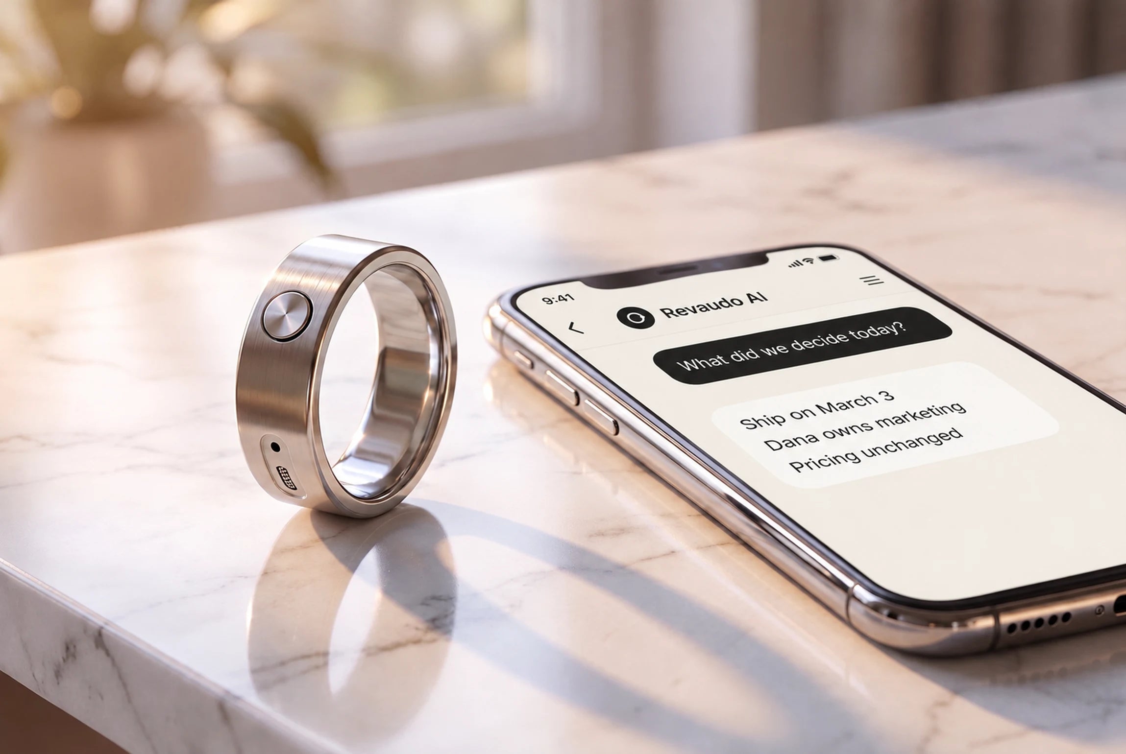 The silver ring standing on a marble counter beside a phone