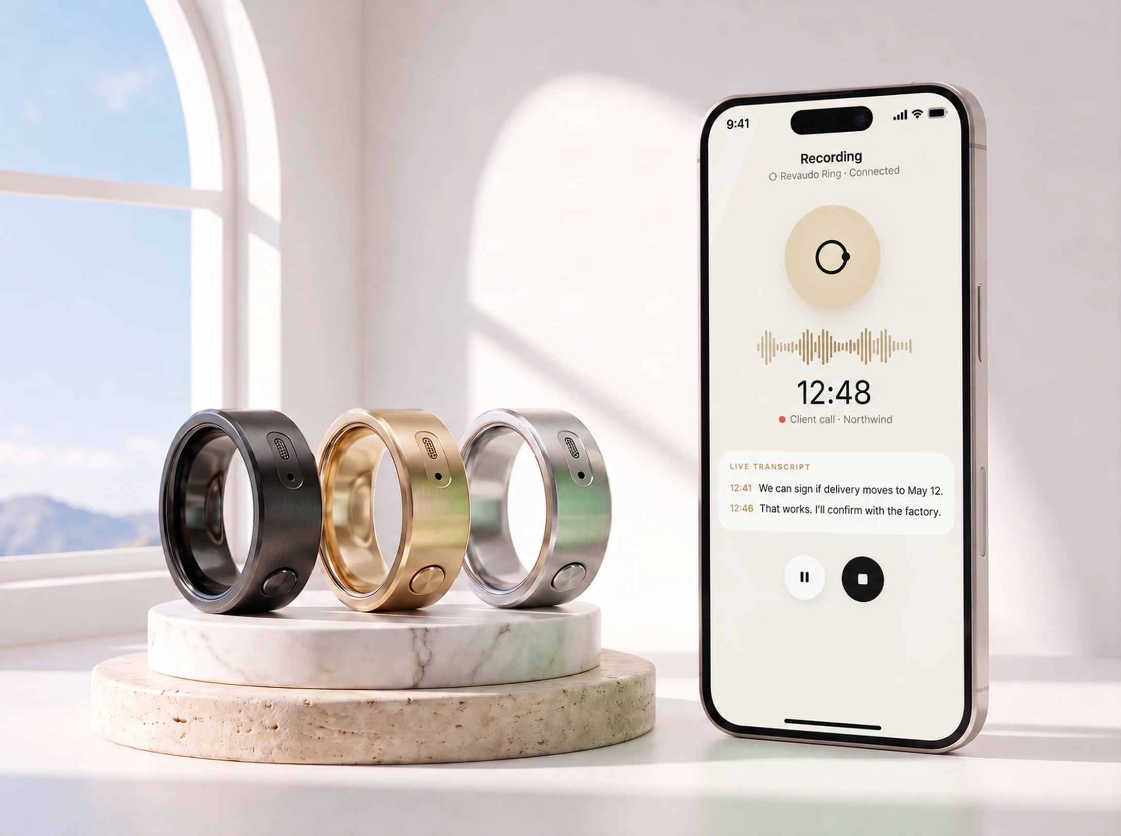 The Revaudo AI Ring in black, gold and silver on stone pedestals beside a phone showing the recording screen